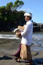 Balinese man bringing his offerings to attend the prayer at Tanah Lot temple