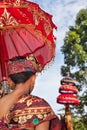 Balinese man in sarong hold umbrella in hindu temple