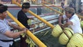 Balinese men preparing Traditional Bali Penjor bamboo pole with decoration