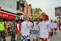 Balinese men in traditional dress bringing offerings to Hindu temple,