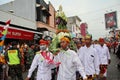 Balinese men in traditional dress bringing offerings to Hindu temple,