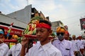 Balinese men in traditional dress bringing offerings to Hindu temple,