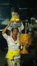 Balinese people carry offerings on their heads after a procession of traditional religious ritual ceremony at village temple. Royalty Free Stock Photo