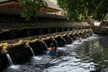 Balinese people praying in holy spring water of sacred pool at Pura Tirta Empul Temple, Tampaksiring, BALI, INDONESIA - Royalty Free Stock Photo