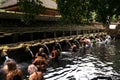 Balinese people praying in holy spring water of sacred pool at Pura Tirta Empul Temple, Tampaksiring, BALI, INDONESIA - Royalty Free Stock Photo