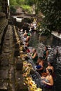 Balinese people praying in holy spring water of sacred pool at Pura Tirta Empul Temple, Tampaksiring, BALI, INDONESIA - Royalty Free Stock Photo