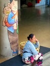 A balinese porter woman sitting on the stairs