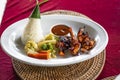 Balinese sea food served with traditional cone shaped leave wrapped rice and vegetables along with sauce