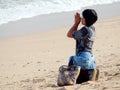 Balinese woman praying on the beach in the morning Royalty Free Stock Photo