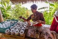 Balinese young woman serving coffee in Bali, Indonesia