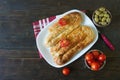 Balkan cuisine. Bureks - popular national dish - with tomatoes and olives. Flat lay. Dark background. Free space for text