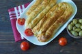 Balkan cuisine. Bureks - popular national dish - on white plate. Dark background