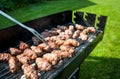 Balkan meatballs called cevapi on barbecue with BBQ fork