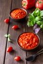 Balkan sauce ajvar in a clay bowl and ingredients for its preparation on a wooden background. Serbian traditional food Royalty Free Stock Photo