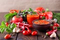 Balkan sauce ajvar and ingredients for its preparation on a wooden table. Royalty Free Stock Photo