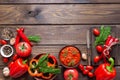 Balkan sauce ajvar and ingredients for its preparation on a wooden table. Serbian traditional food Royalty Free Stock Photo