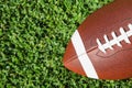 Ball for American football on fresh green field grass, top view. Royalty Free Stock Photo