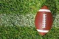 Ball for American football on fresh green field grass Royalty Free Stock Photo