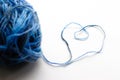 A ball of blue wool yarn. Thread laid out the shape of a heart. Royalty Free Stock Photo