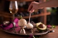 A ball of caramel ice cream with a mint leaf in an ice-cream bowl on a metal vintage tray