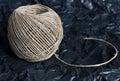 A ball of cord made of natural hemp laid on crumpled black wrapping paper Royalty Free Stock Photo