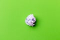 A ball of crumpled office paper on a green background. Royalty Free Stock Photo