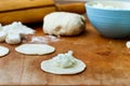Ball of dough, and small pieces of rolled tortillas for dumplings with cottage cheese on a kitchen wooden board