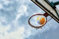 The ball flies into the basketball basket against a cloudy sky Royalty Free Stock Photo