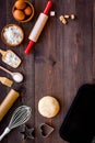 Ball of fresh raw dough near ingedients and cookware on dark wooden background top view space for text Royalty Free Stock Photo