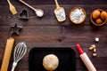 Ball of fresh raw dough near ingedients and cookware on dark wooden background top view space for text Royalty Free Stock Photo