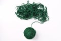 Ball of green thread and tangled threads on a white background