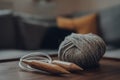 Ball of grey chunky wool yarn and large circular knitting needles on a wooden table Royalty Free Stock Photo