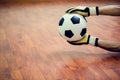 Ball in hands of futsal goalkeeper on wooden futsal floor Royalty Free Stock Photo