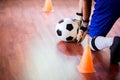 Ball in hands of futsal goalkeeper on wooden futsal floor. Indoor soccer sports hall Royalty Free Stock Photo