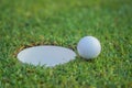 The ball at the hole on the golf course. Golf ball putting on green grass near hole golf to win in game at golf course with blur Royalty Free Stock Photo