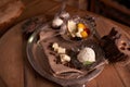 A ball of ice cream in an old ice-cream bowl on a vintage tray with white chocolate and grains of coffee,