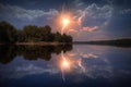 ball lightning reflecting on a calm lake surface