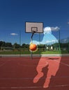 The ball in the player`s hands flies into the basketball ring on a sunny and clear day. Contour image of a basketball player. Mult