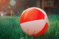 The ball is a two colors white and red pattern on the green grass Royalty Free Stock Photo