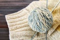 A ball of wool with knitting needles and knitted socks on a wooden table. Needlework. Royalty Free Stock Photo