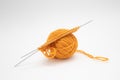 Ball of woolen thread for knitting orange color and knitting needles Royalty Free Stock Photo