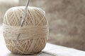 Ball of yarn with crochet hook and beige cotton thread, close-up Royalty Free Stock Photo