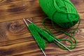 Ball of yarn and knitting needles with knitting on wooden table Royalty Free Stock Photo