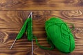 Ball of yarn and knitting needles with knitting on wooden table. Top view Royalty Free Stock Photo