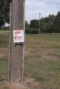 Red and white sign warning of Rabbait 1080 poison laid to cull pest wild rabbits causing