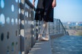 Ballerina in ballet legs in shoes and black tutu dancing by the fence. Beautiful young woman in black dress and pointe dancing