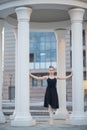 Ballerina in a black dress is a beautiful pose. A beautiful young woman in a black bodysuit is dancing in an elegant classical Royalty Free Stock Photo