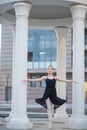 Ballerina in a black dress is a beautiful pose. A beautiful young woman in a black bodysuit is dancing in an elegant classical Royalty Free Stock Photo