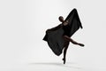 Beautiful ballerina with black veil dancing on light background, space for text. Dark silhouette of dancer