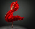 Ballerina dancing with Red Silk Fabric flying on Wind. Modern Ballet Dancer jumping over Dark Studio background. Fashion Woman in Royalty Free Stock Photo